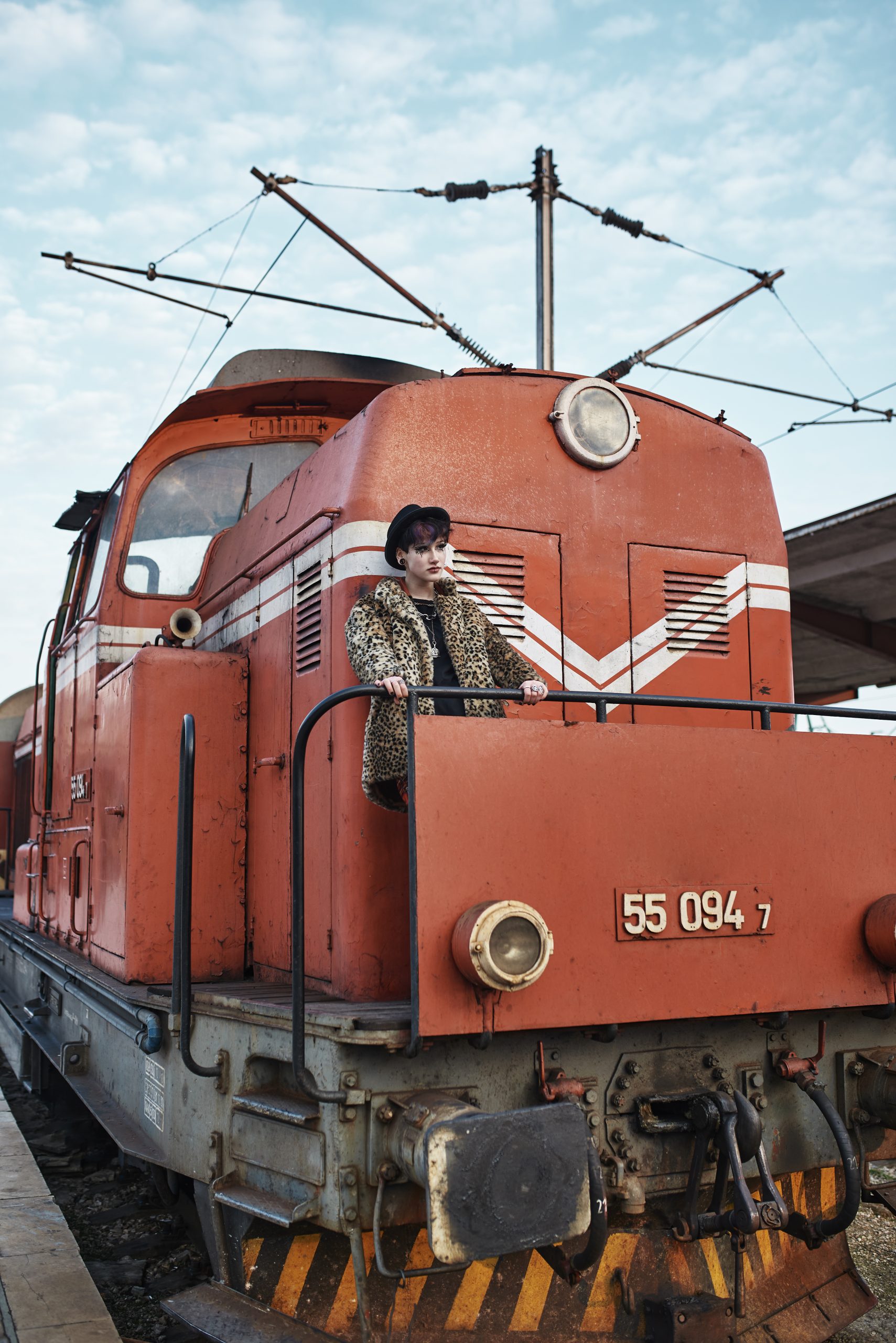 pop punk aesthetic portrait woman posing by locomotive scaled