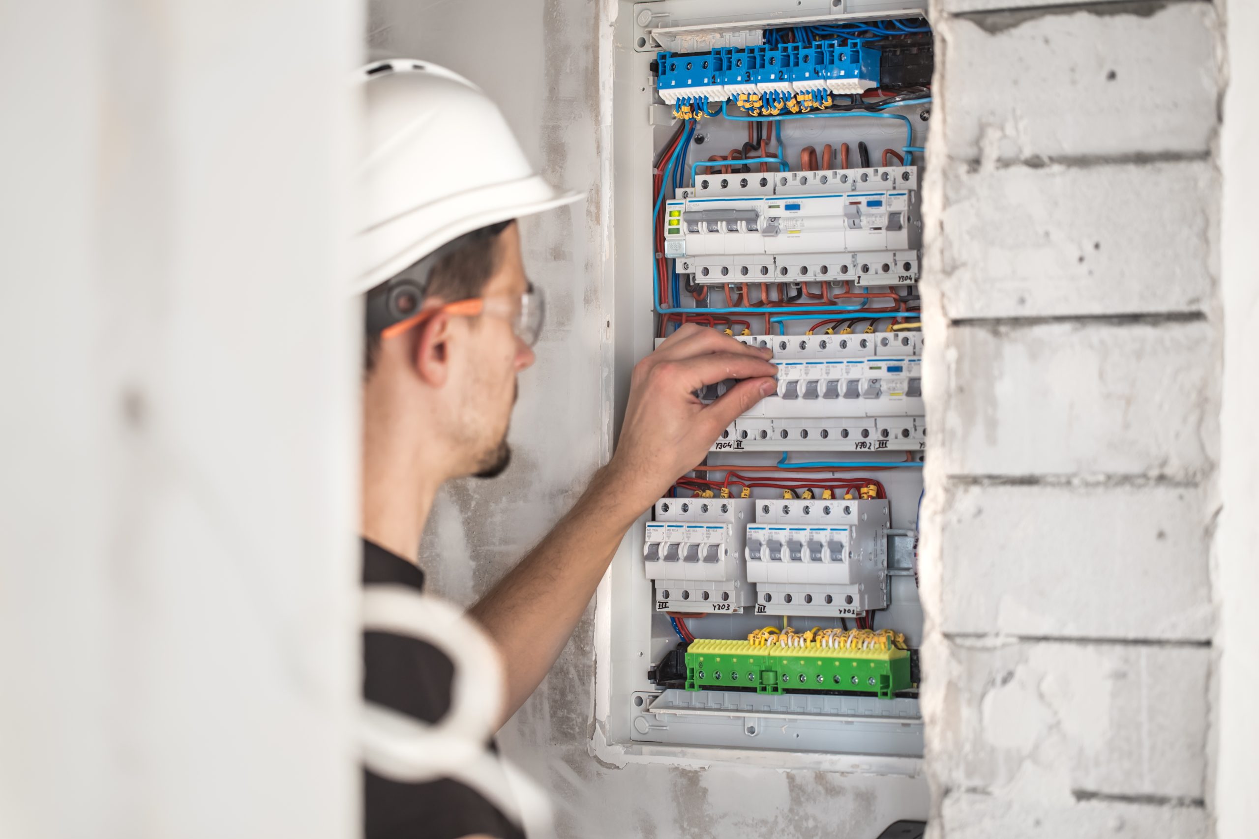 Guvernul pregătește noi măsuri pentru protejarea consumatorilor vulnerabili în contextul eliminării plafonării prețurilor la energie 1 man electrical technician working switchboard with fuses installation connection electrical equipment 1 scaled