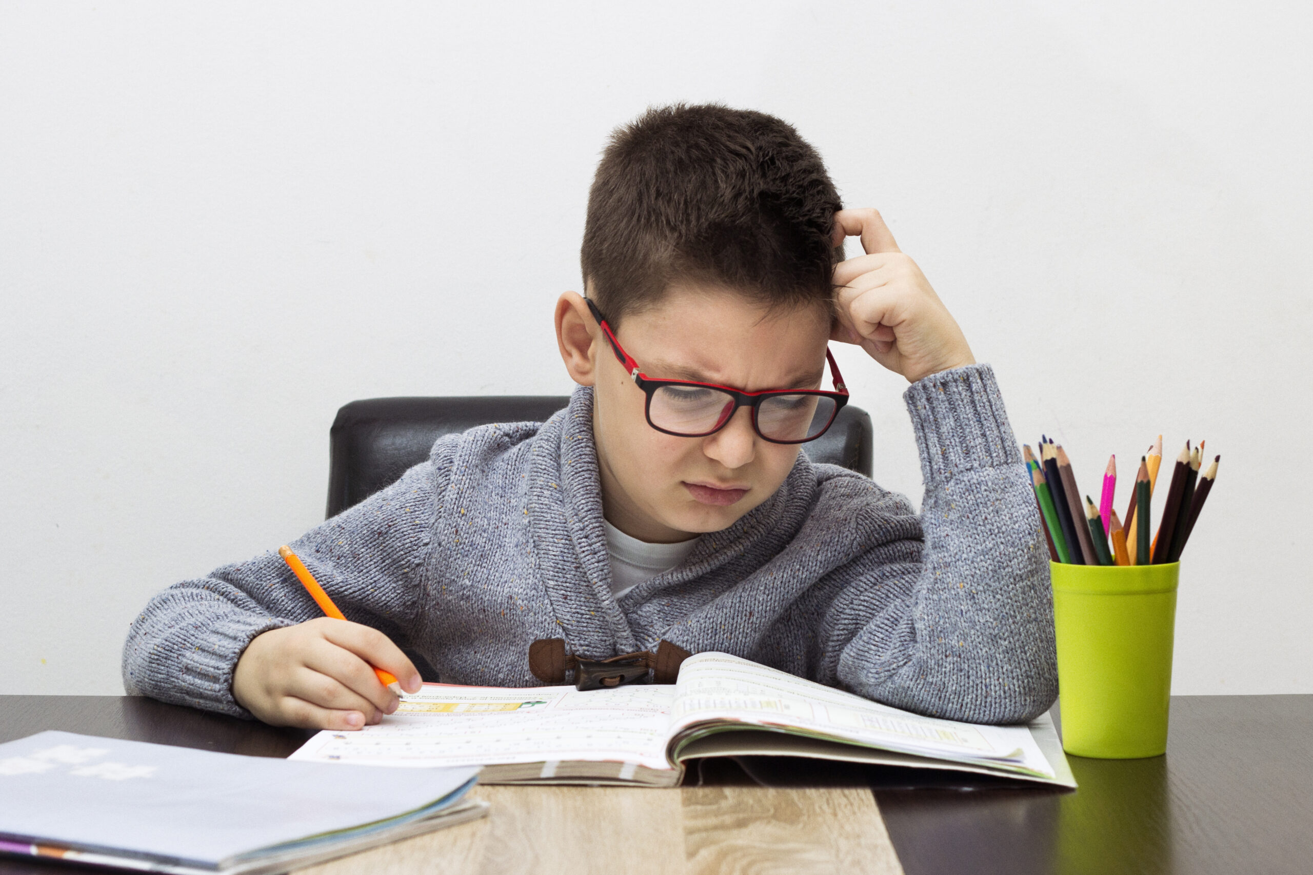 young boy frustrated homework writing home boy studying table kid drawing with pencil scaled